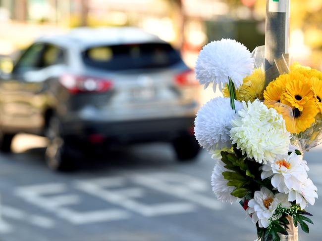 Flowers on a pole at the intersection of Bridge Rd and Peats Ferry Rd following the death of an 81-year-old pedestrian last month.