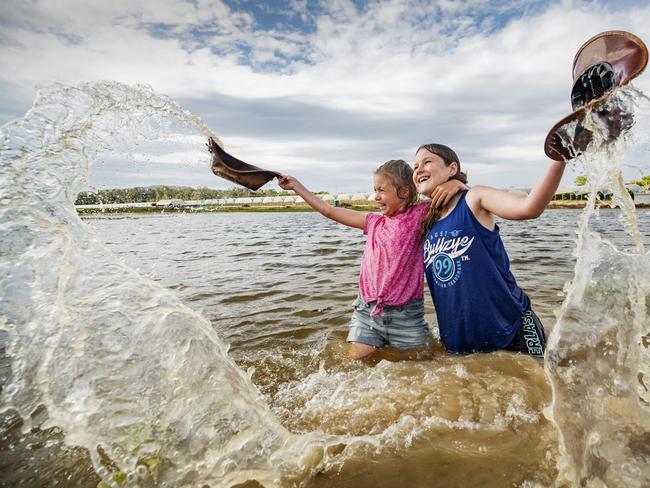 Sisters Kasey 8, and Jessica Hewitt, 10, play in the dam on their raspberry farm near Wamuran north of Brisbane, which received a much-needed 50mm from storms in the past few days. Picture: Lachie Millard