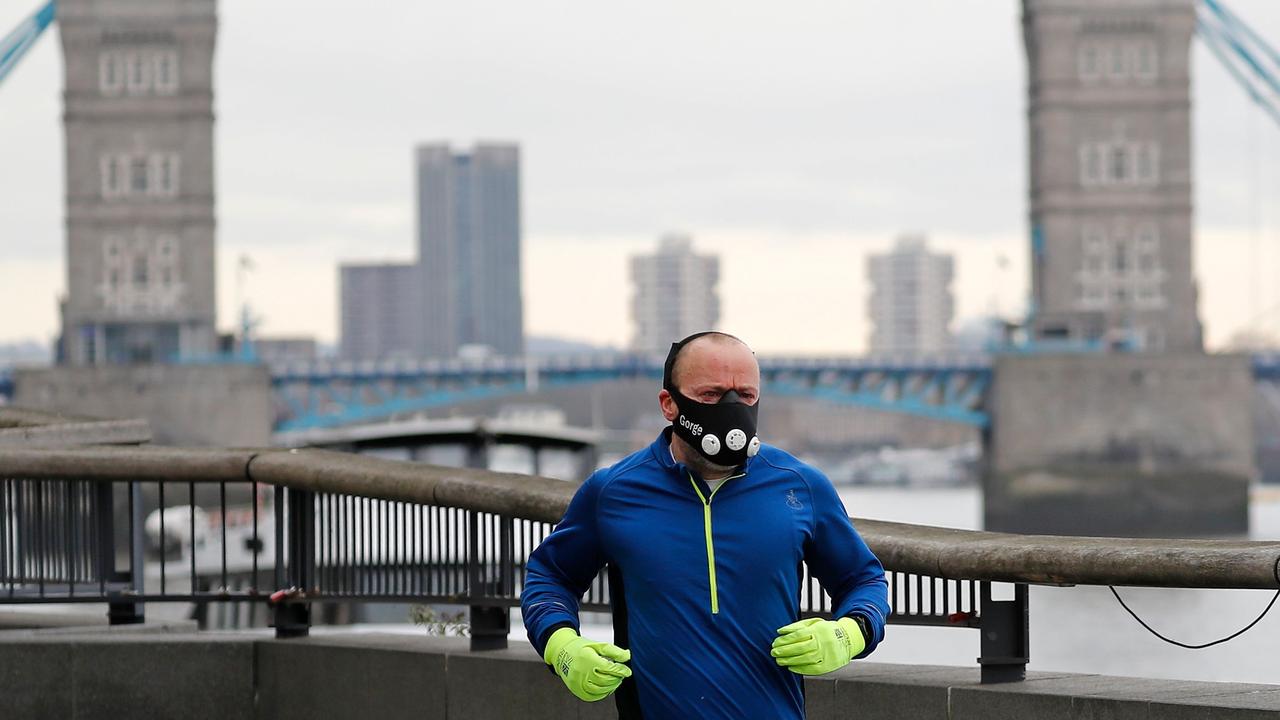 A man jogs along the banks of the River Thames to take his daily exercise allowance near Tower Bridge in London. Picture: Tolga Akmen/AFP)