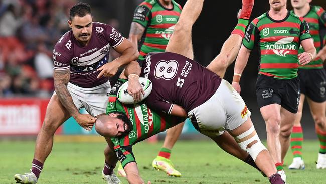 Mark Nicholls of the Rabbitohs is tackled by Josh Aloiai.