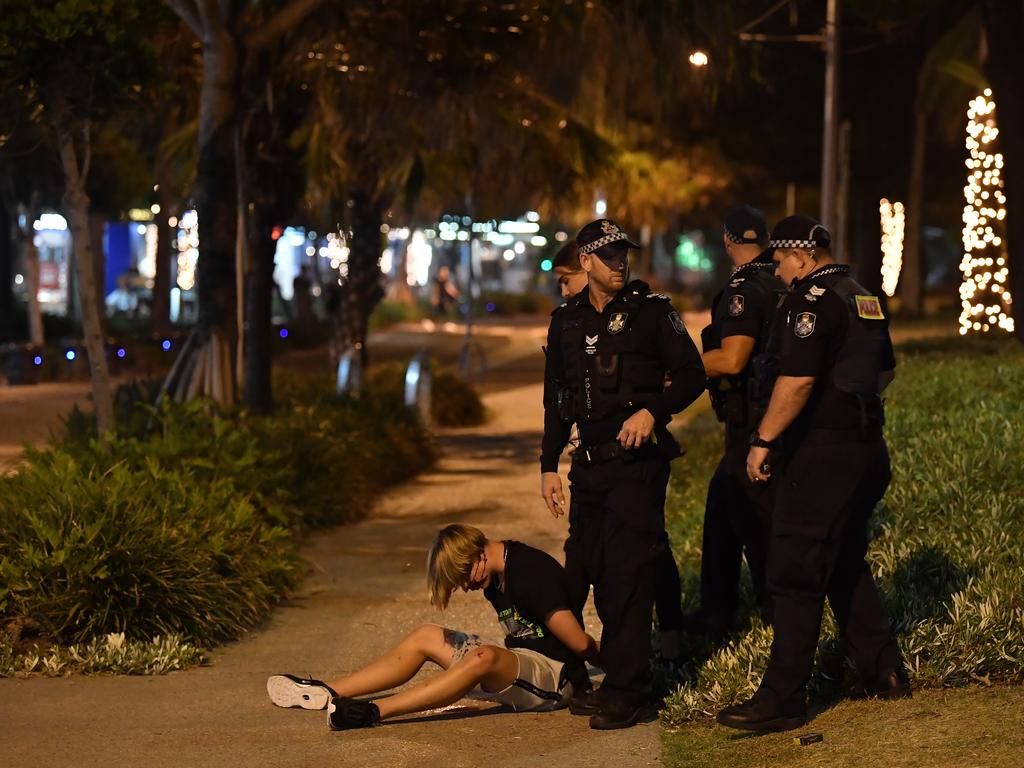 Police speak with an injured man at The Esplanade in Mooloolaba about midnight on New Year’s Eve.