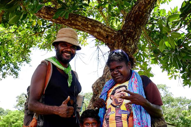 Tiwi locals John Tipiloura, Michaelina Woodroffe and Yelena Ali Tipiloura looked forward to the game as many thousands of spectators made the trip north for a mix of art and footy during this year's 49th Annual Tiwi Grand Final on Bathurst Island, 80km's north of Darwin, NT. Picture: Justin Kennedy