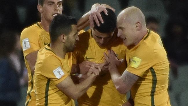 Socceroos players celebrate with Tom Rogic (centre) after he scored the winning goal against Saudi Arabia on Thursday night.