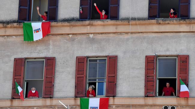 Residents with Italian flags in the Garbatella district of Rome take part on April 25 in a 'Liberation Day' flashmob with people singing Italian partisan song 'Bella Ciao' from their window or balcony, during the country's lockdown.