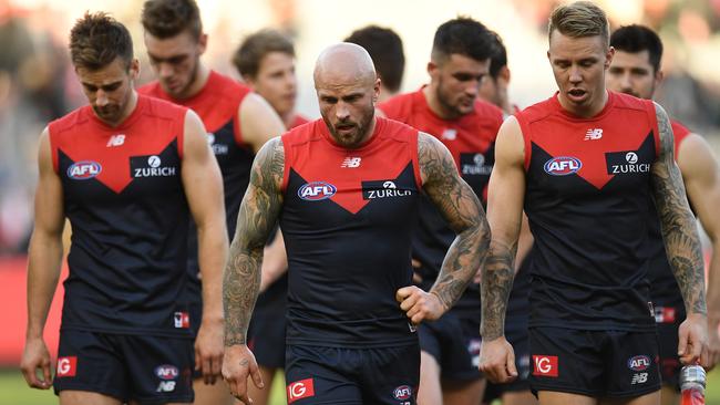 Melbourne players walk off the MCG after their third loss in a row.