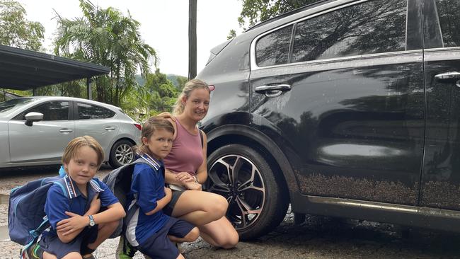 Sarah Lenehan, with her sons Riley and Tyler, had to move her car from flood waters on Clifton Road this morning. Picture: Marcus Wilson.