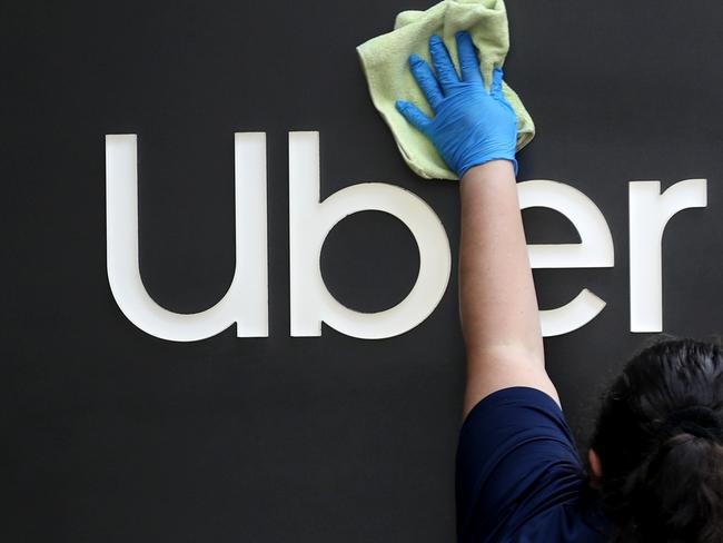 SAN FRANCISCO, CALIFORNIA - MAY 18: A worker cleans a sign in front of the Uber headquarters on May 18, 2020 in San Francisco, California. Uber announced plans to cut 3,000 jobs and shutter or consolidate 40 offices around the world due to severely declining business as the coronavirus (COVID-19) pandemic continues. The cuts come two weeks after Uber cut 3,700 employees.   Justin Sullivan/Getty Images/AFP == FOR NEWSPAPERS, INTERNET, TELCOS & TELEVISION USE ONLY ==