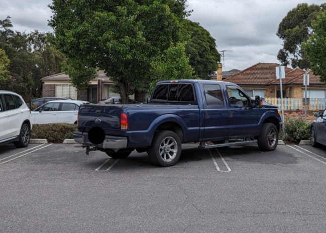 A large American-style ute is parked across three spots in Coburg Village.