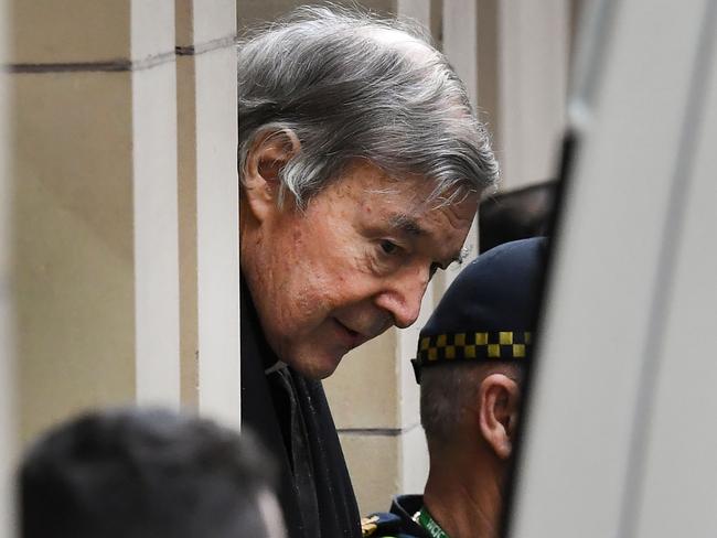 Australian Cardinal George Pell (C) is escorted in handcuffs from the Supreme Court of Victoria in Melbourne on August 21, 2019. - Disgraced Catholic Cardinal George Pell was sent back to jail after an Australian court rejected his landmark appeal against convictions for child sex abuse. (Photo by William WEST / AFP)