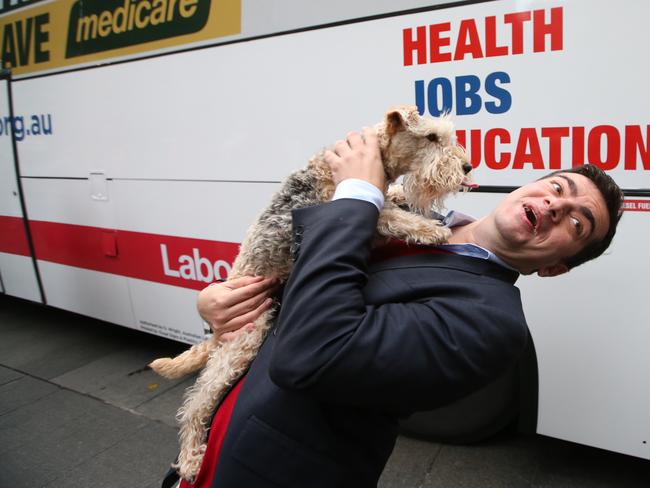 Sam Dastyari kissing a dog before the start of a Medicare rally in Martin Place Sydney. Picture: Kym Smith