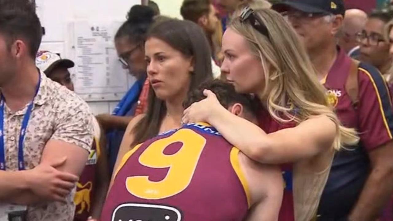 Lachie Neale consoled by his wife. Photo: Channel 7 News.