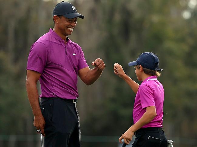 ORLANDO, FLORIDA - DECEMBER 19: Tiger Woods of the United States and son Charlie Woods high five after a birdie on the ninth hole during the first round of the PNC Championship at the Ritz Carlton Golf Club on December 19, 2020 in Orlando, Florida. (Photo by Mike Ehrmann/Getty Images)