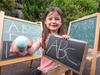 Coco, 6, write with chalk. Qld academic wants schools to get back teaching with chalk and slates. He says it's good for fine motor skills they are missing out on with screens. Picture: Tim Carrafa