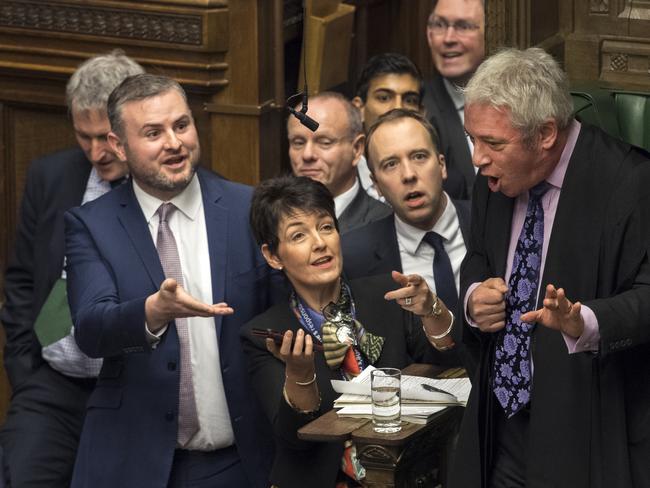 Members of Parliament gather near the Commons Speaker John Bercow, right, including Health Secretary Matt Hancock, front centre 2nd from right, urging Bercow to review a video clip purportedly showing opposition Labour Party leader Jeremy Corbyn muttering remarks during Prime Minister's Questions at the House of Commons in London, Wednesday Dec. 19, 2018.  Corbyn is facing calls to apologise for apparently calling Prime Minister Theresa May a "stupid woman" during Prime Minister's Questions. (Mark Duffy/UK Parliament via AP)