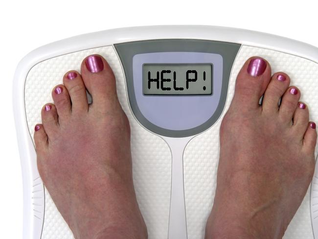 Feet on a bathroom scale with the word help! on the screen. Isolated. Includes clipping path.