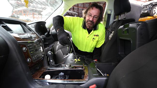 Sharps Australia vehicle safety inspector Mike M clears out a stolen vehicle. Picture: David Clark