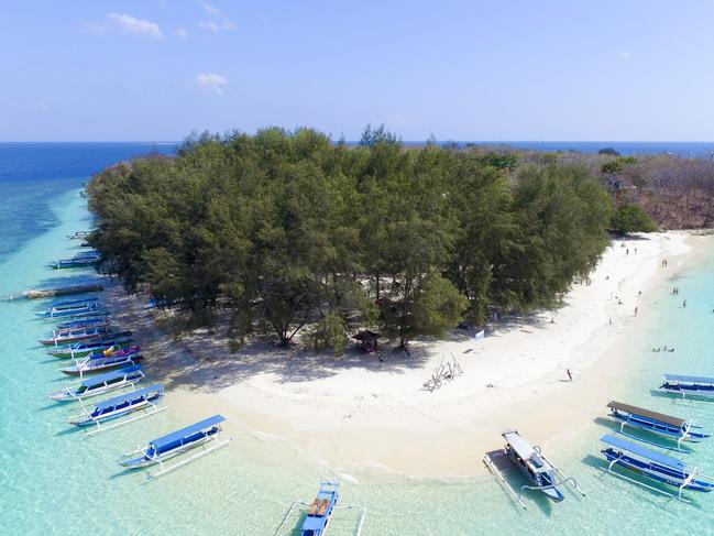 ESCAPE:  Tropical Island. View of nice tropical empty sandy beach with boats, turquoise water in Gili Nanggu Lombok Indonesia Picture: Istock