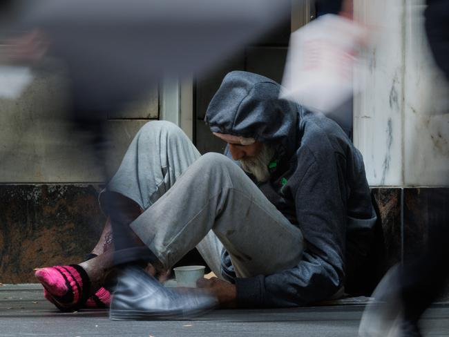 SYDNEY, AUSTRALIA - NewsWire Photos, October 29 2024. GENERIC. Inflation. Shopping. Retail. Economy. Cost of living crisis. Homelessness. Shoppers pass an elderly homeless man with severe wounds / sores on his legs outside a Woolworths in Pitt Street Mall. Picture: NewsWire / Max Mason-Hubers