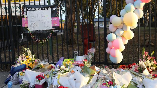 Flowers left at the front gate of the Greenacre school. Picture: John Grainger
