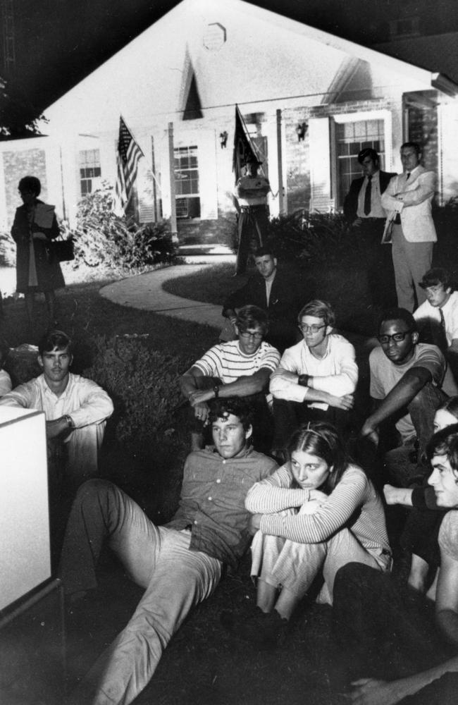 In this July 20, 1969 file photo, people sit on the lawn of the home of Stephen Armstrong in Wapakoneta, Ohio, to watch astronaut Neil Armstrong walk on the moon. The event happened on Sunday evening for American viewers, but Monday lunchtime for Australians. Picture: AP Photo/Bill Sauro