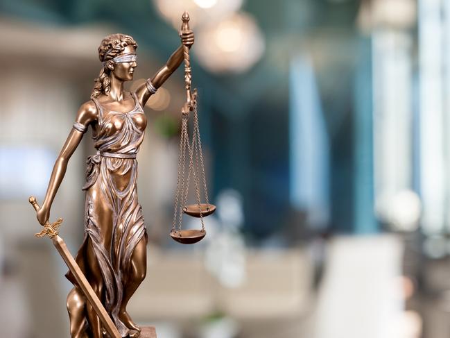 A bronze statue of the Lady Of Justice  composited into a blur background of a law firm. istock image