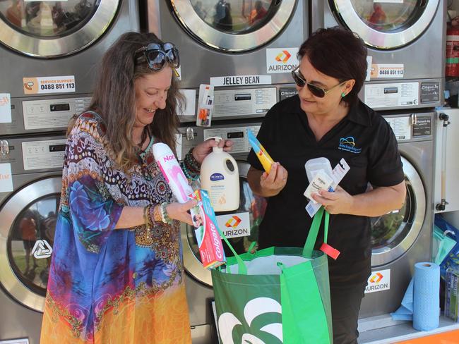 Mandy Kerss and Julie Sercombe go through a hamper at the Mackay Airport cheque and Christmas hamper donation to Orange Sky at Juliet St, Mackay, on Friday, December 16, 2022. Picture: Andrew Kacimaiwai