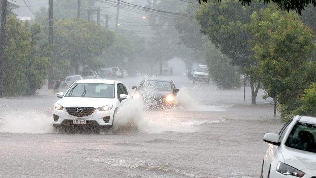 Cars driving though rising water in Beck St in Milton. Picture: Steve Pohlner