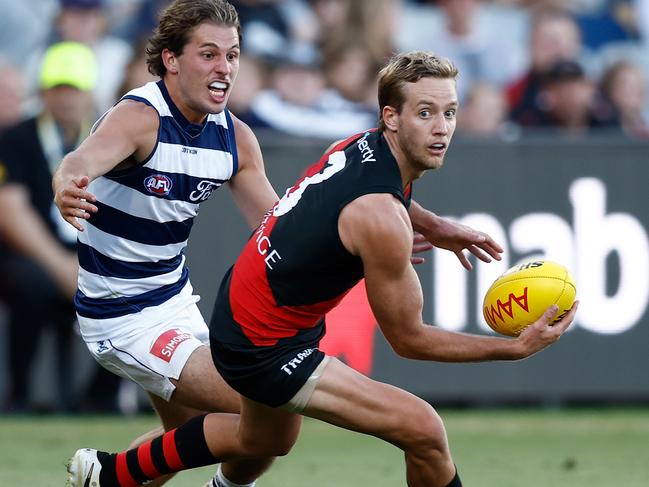 Darcy Parish looks to evade Cats youngster Jhye Clark, with the Bombers midfielders racking up the numbers in the first half. Picture: Michael Willson/AFL Photos via Getty Images.