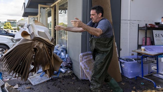 Marco Dilzio cleans up in Brisbane as flood waters recede after the worst flooding in 30 years. Picture: Sarah Marshall