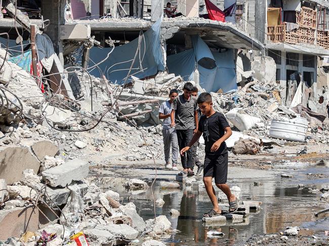 Boys walk on dry bricks to traverse a puddle of sewage water past mounds of rubble along a street in the Jabalia camp for Palestinian refugees in the northern Gaza Strip. Picture: AFP