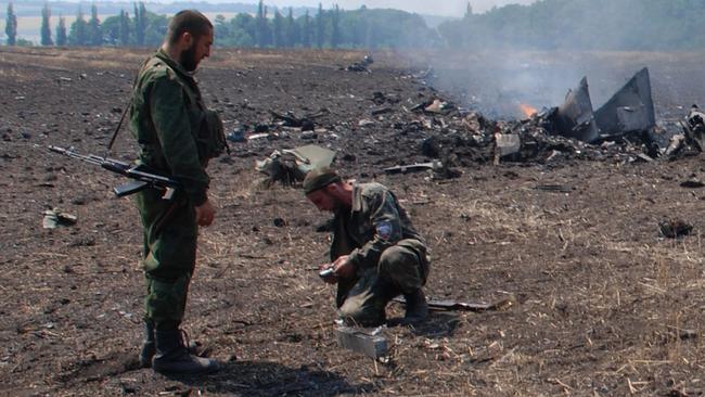 Rebels at the crash scene of a downed Ukrainian jet fighter.