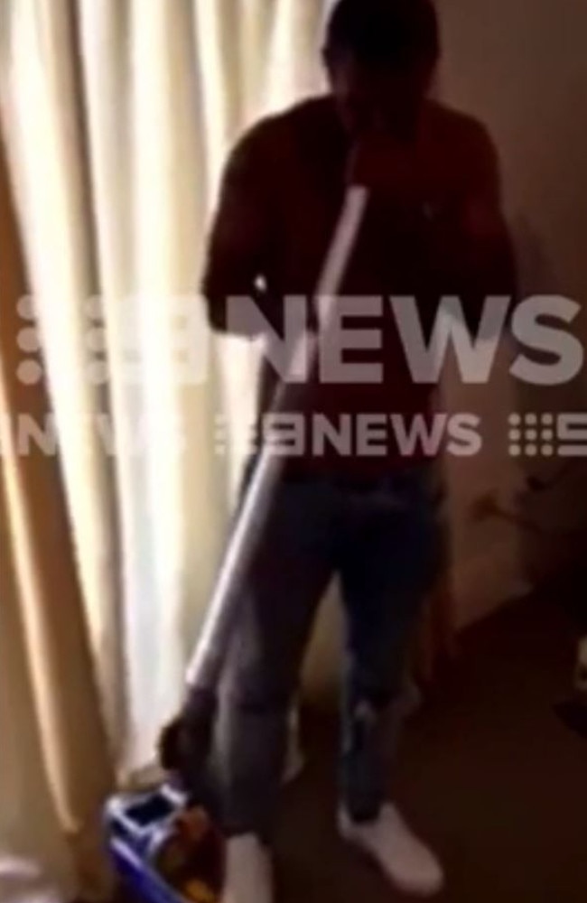 A screengrab from the video allegedly taken in 2015 after the Rugby World Cup showing a shirtless Beale playing a vacuum cleaner as a didgeridoo in a room with others with one man holding a plate with a white powdery substance and a rolled up piece of paper in his other hand. Picture: 9 NEWS