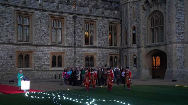 Britain's Queen Elizabeth II touches the Commonwealth Nations Globe to start the lighting of the Principal Beacon outside of Buckingham Palace. Picture: AFP