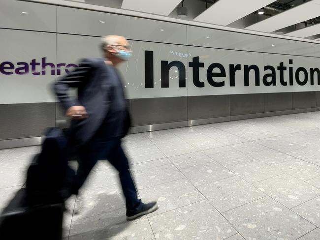 LONDON, ENGLAND - NOVEMBER 26: International passengers walk through the arrivals area at Terminal 5 at Heathrow Airport on November 26, 2021 in London, England. A heavily-mutated new variant of the Covid-19 virus, currently called B.1.1.529, has been detected in South Africa, Botswana and Hong Kong. The U.K. Health Secretary Sajid Javid said from 12:00 GMT on Friday all flights from South Africa, Namibia, Zimbabwe, Botswana, Lesotho and Eswatini are being suspended and the countries added to the UK's travel Red List. (Photo by Leon Neal/Getty Images)