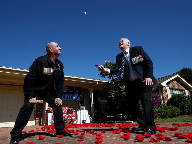 Vietnam veteran Ray James and son-in-law Grant Whalan who served in the Australian Army as an engineer play two-up in the driveway of Ray's home. Picture: Toby Zerna