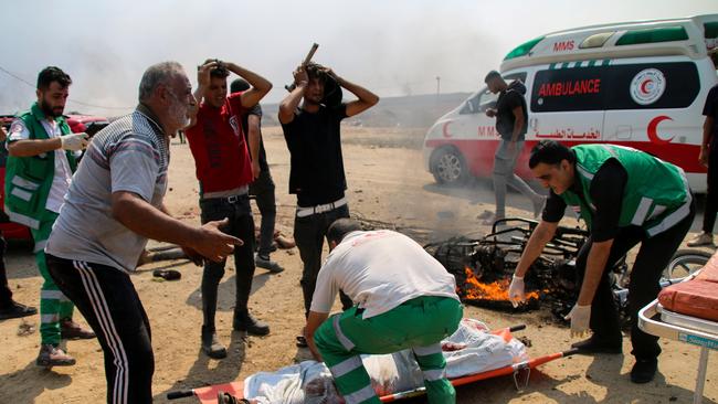 Paramedics transport the bodies of two young Palestinians whose motorcycle was targeted near the border fence between the Gaza Strip and Israel. Picture: Getty