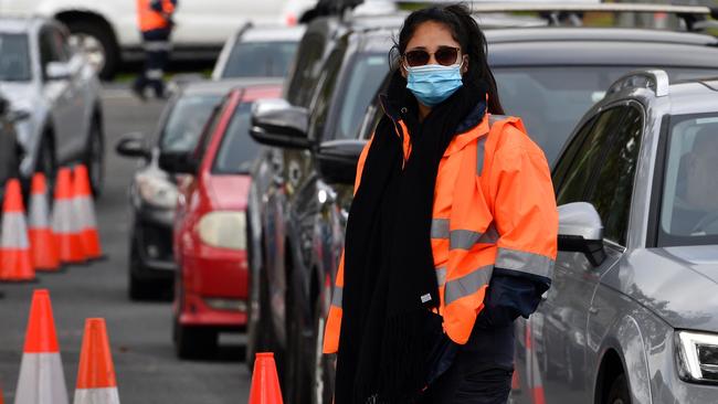 A traffic worker directs motorists at a COVID-19 testing station in Sydney. Picture: Saeed Khan/AFP