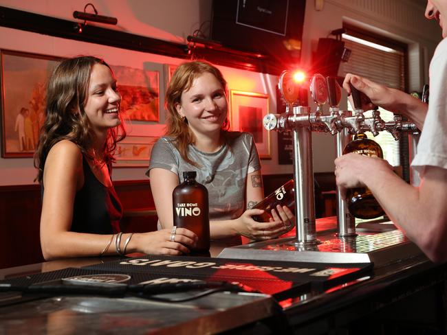 Alice Waters Mooney and Miette Grenard-Long grabbing take away wine from the tap, poured into bottles known as “squealers”, at the Erko pub in Erskinville. Picture: Richard Dobson