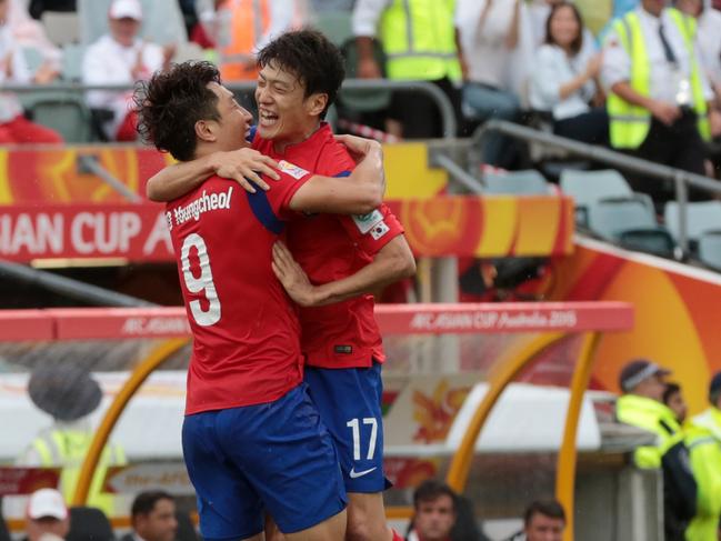 South Korea's Cho Young Cheol, left, celebrates with teammate Lee Chung Yong after scoring a goal during the first round soccer match of the AFC Asia Cup between Korea and Oman in Canberra, Australia, Saturday, January 10, 2015. (AP Photo/Andrew Taylor)