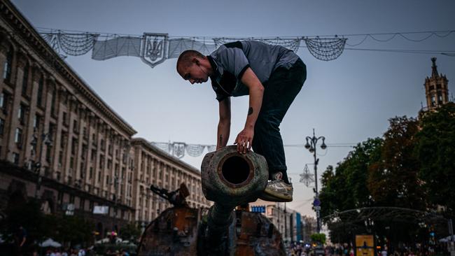 A man on top of a destroyed Russian tank at Khreshchatyk street in Kyiv. Picture: Dimitar Dilkoff/AFP