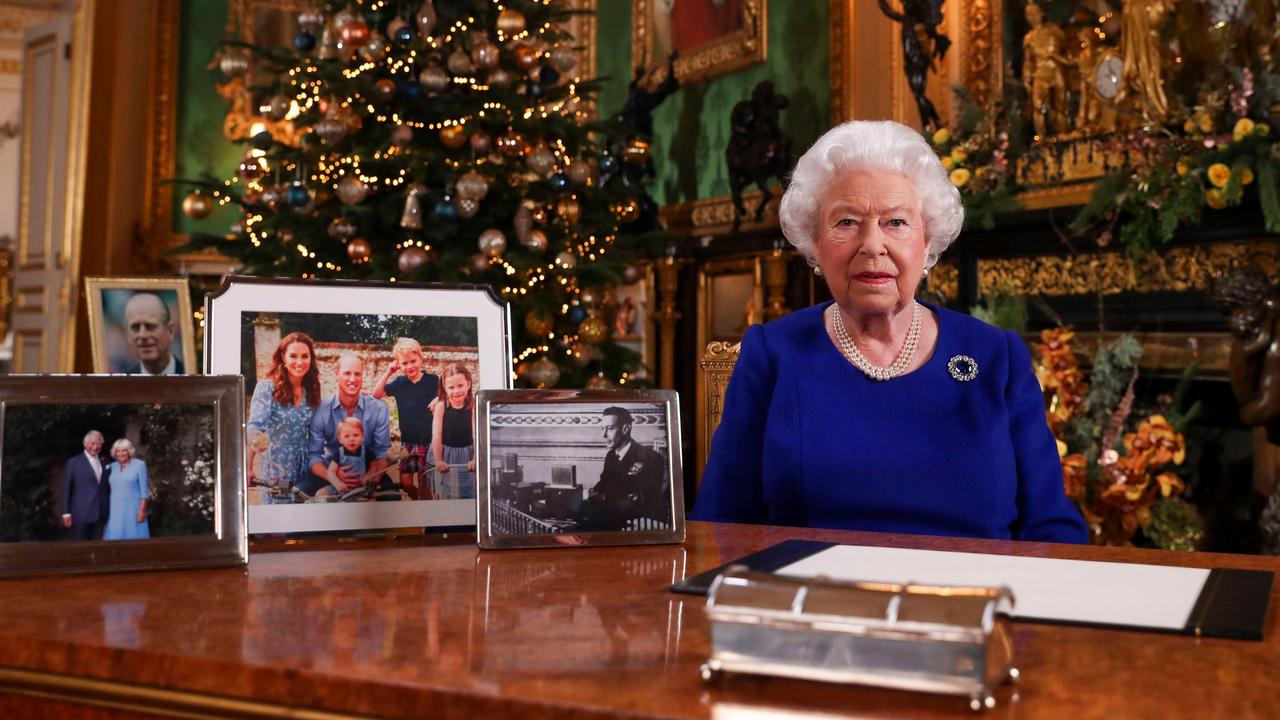 The Queen posing for a photo after recording her Christmas message, to be broadcast tomorrow. Note the pictures next to her. Picture: Steve Parsons/AFP