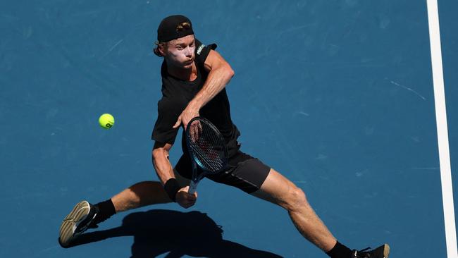 Australia's Dane Sweeny hits a return against Argentina's Francisco Cerundolo during their men's singles match on day one of the Australian Open tennis tournament in Melbourne on January 14, 2024. (Photo by Martin KEEP / AFP).