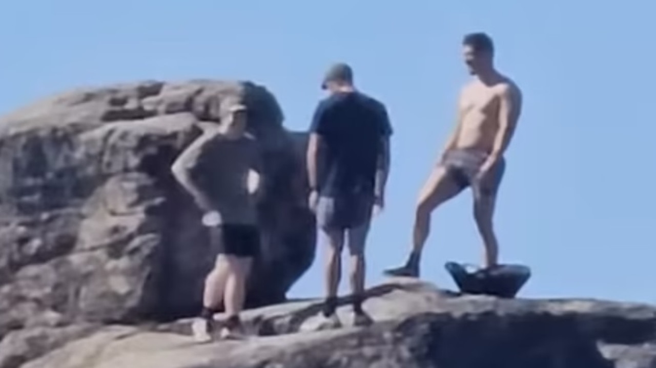 Photo of men standing on rock sparks outrage