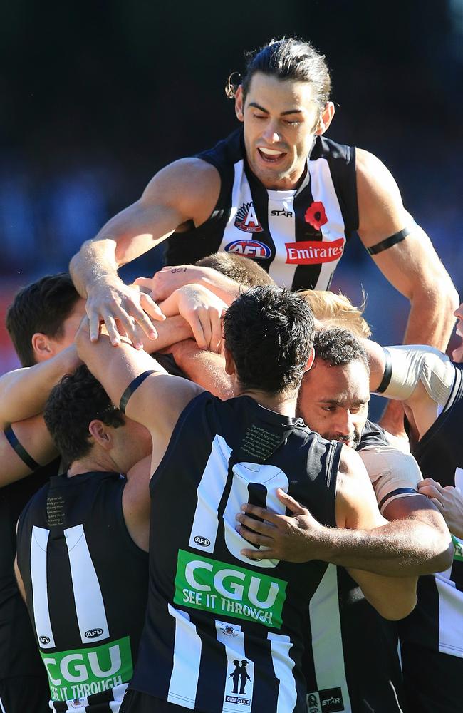 Brodie Grundy (top) and Collingwood players surround Mason Cox after his early goal. Picture: Wayne Ludbey