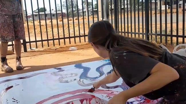 An investigation by The Australian has unearthed video of a white arts centre manager painting on the canvas of Indigenous artist Yritji Young in the APY Lands.