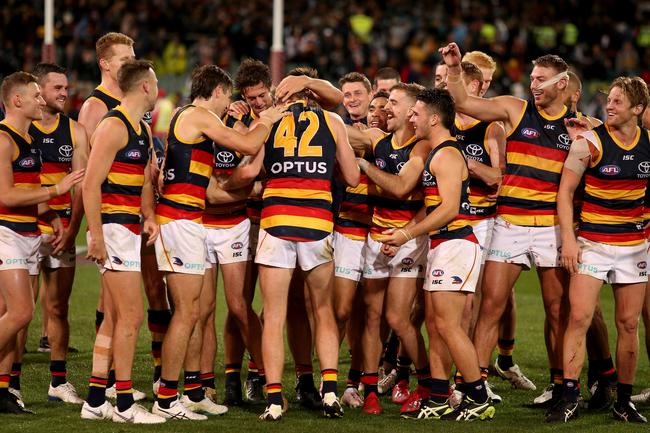 Crows Alex Keath is congratulated by his Crows team-mates for being awarded the Showdown medal at Adelaide Oval. Picture: James Elsby/Getty