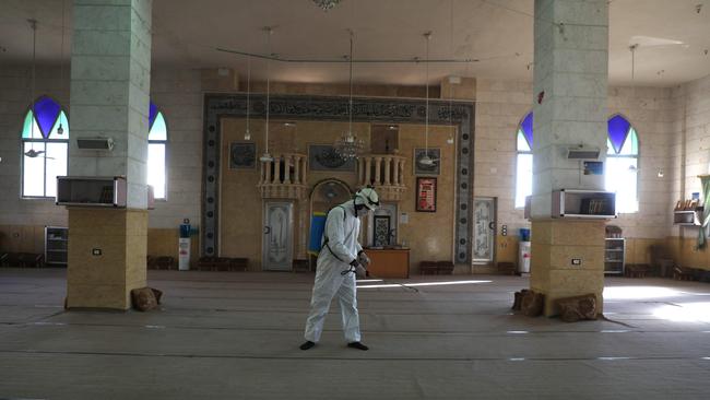 A member of the Syrian Civil Defence, known as the “White Helmets”, disinfects the interior of a mosque. Picture: AFP