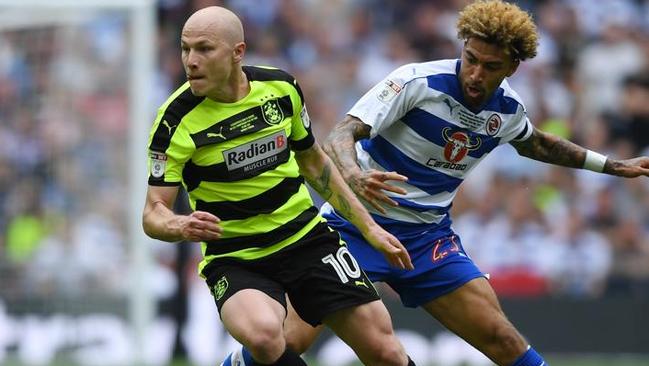 Aaron Mooy of Huddersfield Town attempts to get away from Daniel Williams of Reading.