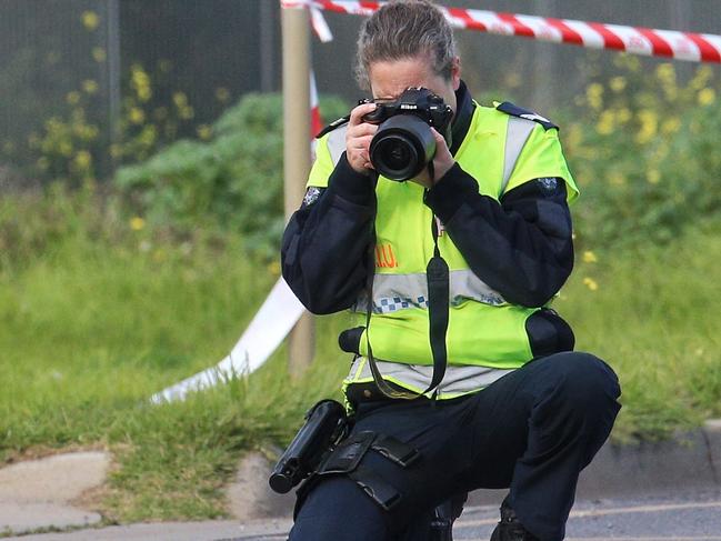 A crash investigator examines the road after a car crash. Picture: Hamish Blair