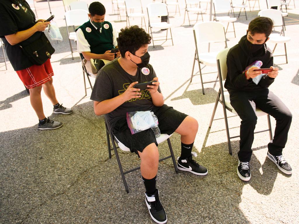 David Morales, 15, (L) and brother Daniel Morales, 14, receive the Pfizer vaccine in Los Angeles. Picture: AFP